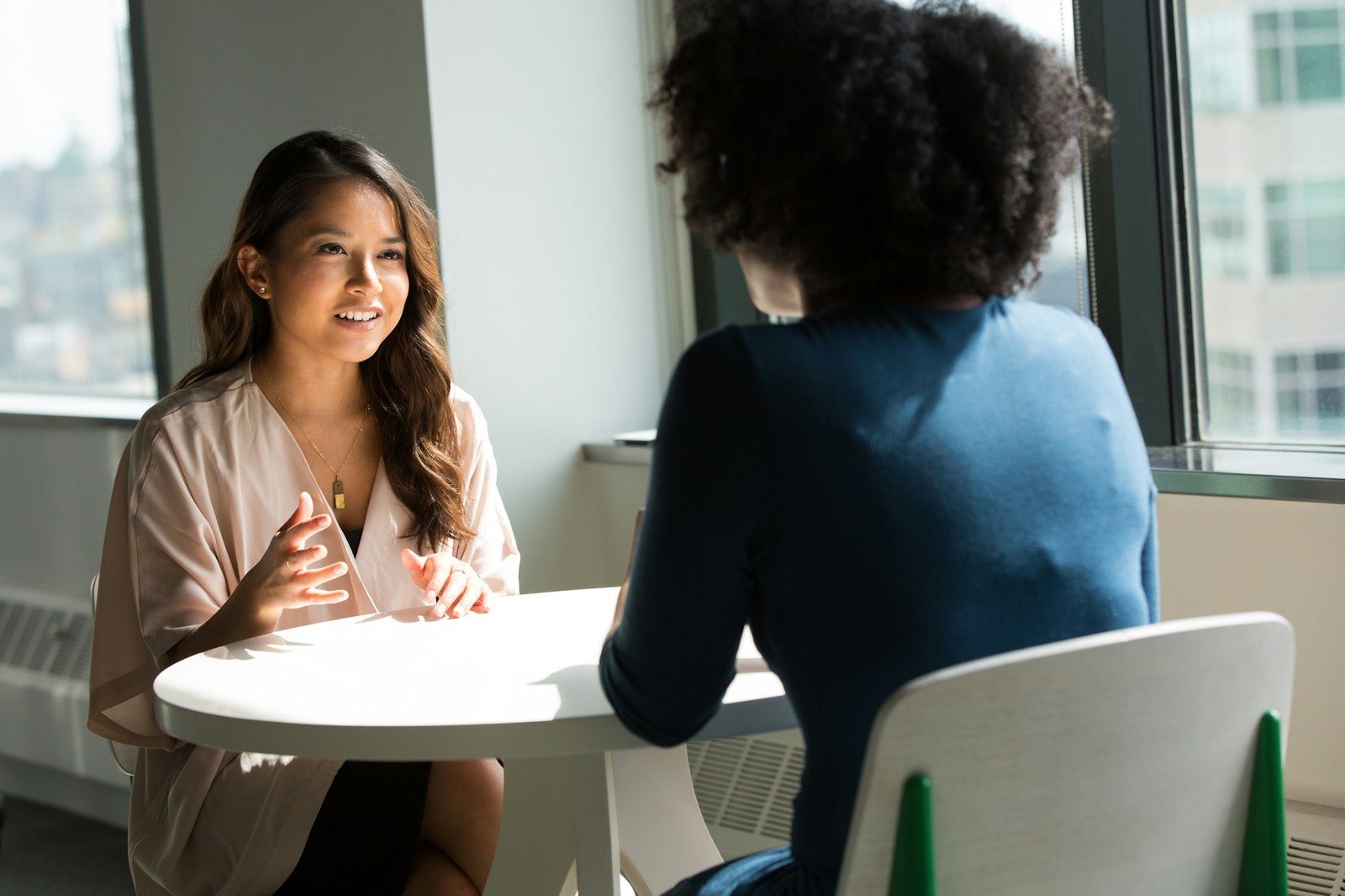 Two professionals in a warm, one-to-one mentoring conversation