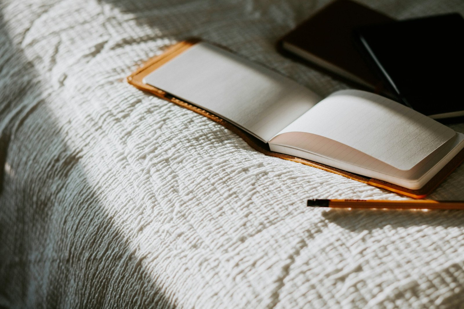 An open journal and pencil resting in quiet morning light